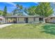 Charming single-story home with a well-manicured lawn, covered parking, and inviting front entrance at 210 Pinehurst Dr, Auburndale, FL 33823