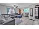 Comfortable living room with large sectional sofa, tile floors, and bright natural light at 210 Pinehurst Dr, Auburndale, FL 33823