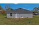 The backyard of a grey home with a dark shingle roof at 225 Babson Dr, Babson Park, FL 33827