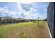 Spacious backyard featuring lush green grass, perfect for outdoor activities and relaxation with a view of neighborhood pools at 225 Highgate Park Blvd, Davenport, FL 33897