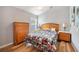 Cozy bedroom features a wood dresser, bedside tables, and a patterned bedspread at 225 Highgate Park Blvd, Davenport, FL 33897