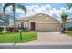 Charming single-Gathering home with a well-manicured lawn, beautiful landscaping, and a brick paver driveway at 225 Highgate Park Blvd, Davenport, FL 33897