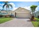 Charming single-Gathering home with a well-manicured lawn, beautiful landscaping, and a brick paver driveway at 225 Highgate Park Blvd, Davenport, FL 33897