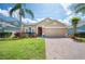 Charming single-Gathering home with a well-manicured lawn, beautiful landscaping, and a brick paver driveway at 225 Highgate Park Blvd, Davenport, FL 33897