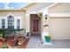 Inviting front entrance with a beautiful red door, manicured landscaping, and a charming brick paver walkway at 225 Highgate Park Blvd, Davenport, FL 33897