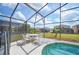 Relaxing screened-in pool area with outdoor seating and beautiful backyard view at 225 Highgate Park Blvd, Davenport, FL 33897