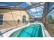 Sparkling pool inside screened-in lanai is surrounded by mature landscaping at 225 Highgate Park Blvd, Davenport, FL 33897