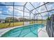 Sparkling pool inside screened-in lanai offers a peaceful backyard view at 225 Highgate Park Blvd, Davenport, FL 33897