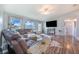 Sun-filled living room featuring a large sectional, wood-look floors, and backyard views at 238 Lake Eloise Pointe Blvd, Winter Haven, FL 33880