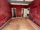 View of a bedroom with dark red walls, closet doors, and view to other rooms of the home at 261 Acacia Walk, Lake Wales, FL 33898