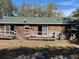 Back exterior view of home featuring a green roof, wood siding, and back patio at 261 Acacia Walk, Lake Wales, FL 33898