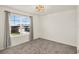 Bright bedroom featuring a window with blinds, light gray carpet and modern light fixture at 271 Inman Blvd, Winter Haven, FL 33881