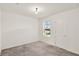 The bedroom features carpeted floors, a window and a white door at 271 Inman Blvd, Winter Haven, FL 33881