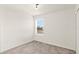 This bedroom features neutral carpet, a bright window and white walls with white trim at 271 Inman Blvd, Winter Haven, FL 33881