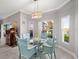 Bright dining area with a glass table, unique chairs, and a view of the outdoors through large windows at 3014 Ashton Palms Dr, Lake Wales, FL 33859