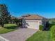 Inviting single-story home with brick driveway, attached garage, and vibrant green landscaping at 3014 Ashton Palms Dr, Lake Wales, FL 33859