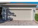 Attached two-car garage with brick paver driveway and neatly trimmed landscaping at 3014 Ashton Palms Dr, Lake Wales, FL 33859