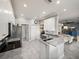 Well-lit kitchen with stainless steel appliances, granite countertops, and tiled floors in an open-concept layout at 3014 Ashton Palms Dr, Lake Wales, FL 33859