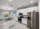 Modern kitchen with stainless steel appliances, granite countertops, and sleek white cabinetry at 3014 Ashton Palms Dr, Lake Wales, FL 33859