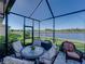 Relaxing screened-in patio with a table and chairs overlooking the lake at 3014 Ashton Palms Dr, Lake Wales, FL 33859