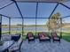 Screened-in patio with comfortable seating and a serene lake view at 3014 Ashton Palms Dr, Lake Wales, FL 33859