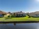 Rear view of home with a screened lanai, backyard, and water view, nestled in a well-maintained community at 3014 Ashton Palms Dr, Lake Wales, FL 33859