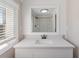 Bathroom vanity with white cabinets, white countertop and large mirror at 319 Thomas Ave, Frostproof, FL 33843