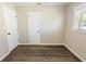 Neutral bedroom featuring two closets, wood-look flooring, and a window for natural light at 319 Thomas Ave, Frostproof, FL 33843