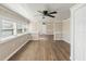 Inviting living room with wood-look flooring, multiple windows, and a ceiling fan for added comfort at 319 Thomas Ave, Frostproof, FL 33843