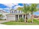 Beautiful exterior with blue shutters and a brick driveway, complemented by lush landscaping and a palm tree at 3217 La Salle St, Winter Haven, FL 33884
