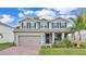 Charming two-story home features a well-manicured lawn, brick driveway, and eye-catching blue shutters at 3217 La Salle St, Winter Haven, FL 33884