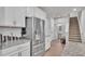 Modern kitchen area featuring stainless steel appliances, granite counters, and stairs to the second floor at 3217 La Salle St, Winter Haven, FL 33884