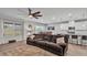 Spacious living room featuring a large brown sectional couch, ceiling fan and a view of the kitchen and dining area at 3217 La Salle St, Winter Haven, FL 33884