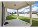Covered patio looking out onto a well-maintained, grassy backyard enclosed by a white fence at 336 Summer Squall Rd, Davenport, FL 33837