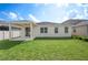 Lush backyard featuring a covered patio, green lawn, and a view of neighboring homes at 336 Summer Squall Rd, Davenport, FL 33837