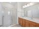 Bright bathroom with a glass-enclosed shower, double sinks, and a large mirror at 336 Summer Squall Rd, Davenport, FL 33837