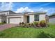 Charming single-story home featuring a two-car garage, blue front door, brick driveway, and well-maintained landscaping at 336 Summer Squall Rd, Davenport, FL 33837