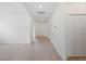 Hallway featuring neutral walls and carpet, leading to the front door at 336 Summer Squall Rd, Davenport, FL 33837