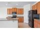 Modern kitchen featuring an island, tile flooring, granite countertops, stainless steel appliances, and wood cabinets at 336 Summer Squall Rd, Davenport, FL 33837