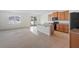 Open kitchen featuring an island, tile flooring, stainless steel appliances, and seamless flow into a carpeted living area at 336 Summer Squall Rd, Davenport, FL 33837