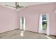 A pink bedroom with carpet flooring, a ceiling fan, and two large windows dressed with white curtains at 3731 Red Oak Ct, Lake Wales, FL 33898