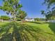 Lush backyard with well maintained lawn, large trees, and a glimpse of the home's exterior at 3736 Knights Station Rd, Lakeland, FL 33810