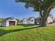 Lush backyard with a white home, a shed, and a mature tree at 3736 Knights Station Rd, Lakeland, FL 33810