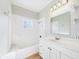 Well-lit bathroom with a tiled shower-tub combo and a vanity with storage at 3736 Knights Station Rd, Lakeland, FL 33810