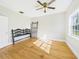 Bedroom boasts a large window, ceiling fan, and hardwood floors for a cozy feel at 3736 Knights Station Rd, Lakeland, FL 33810