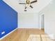 A bedroom featuring a bright blue wall, hardwood floors and ceiling fan at 3736 Knights Station Rd, Lakeland, FL 33810
