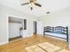 Bright bedroom featuring hardwood floors, ceiling fan, and a closet for ample storage at 3736 Knights Station Rd, Lakeland, FL 33810