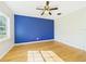 Bright bedroom with a striking blue accent wall, hardwood floors, and natural light from the window at 3736 Knights Station Rd, Lakeland, FL 33810
