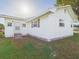 Exterior angle view of the house showing traditional design, white siding, and a well maintained lawn at 3736 Knights Station Rd, Lakeland, FL 33810