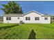 Exterior of a white home with well maintained lawn and air conditioning unit at 3736 Knights Station Rd, Lakeland, FL 33810